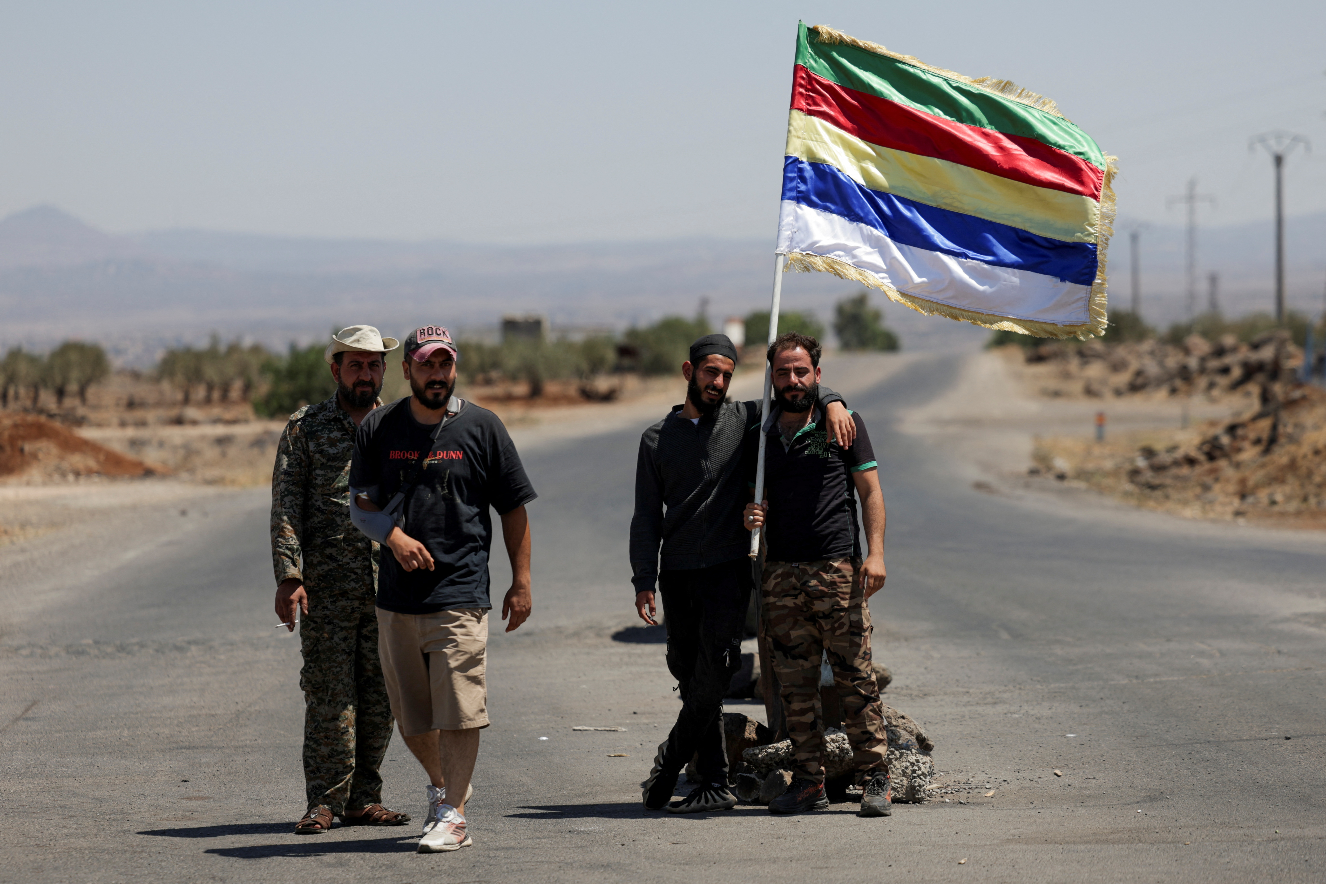 People hold a Druze flag, following deadly clashes between Druze fighters, Sunni Bedouin tribes and government forces, in Syria’s predominantly Druze city of Sweida, Syria July 25, 2025. (Reuters/File)