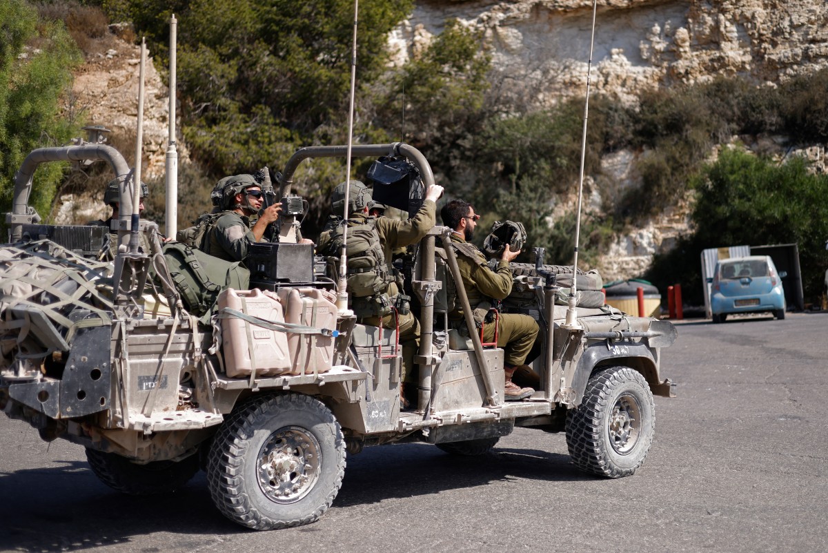 İsrail askerleri, kuzey İsrail'deki Roş HaNikra'da, güney Lübnan'a girmeye hazırlanırken bir araçla yolda ilerliyor. (AFP)