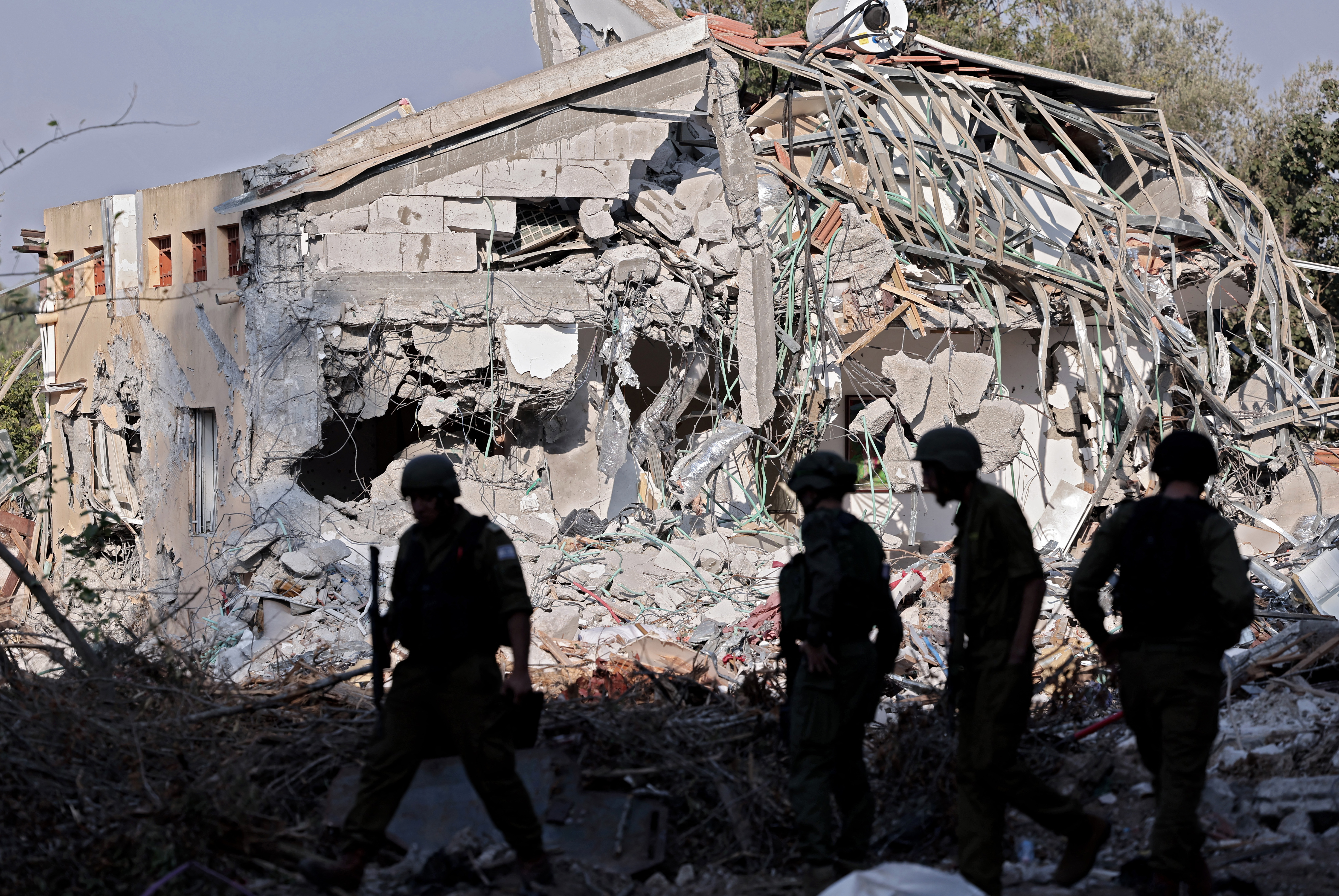 Israeli soldiers walk past a house destroyed by Hamas in the Oct. 7 attack on kibbutz Beeri near the border with Gaza, on Oct. 14, 2023. (AFP file)