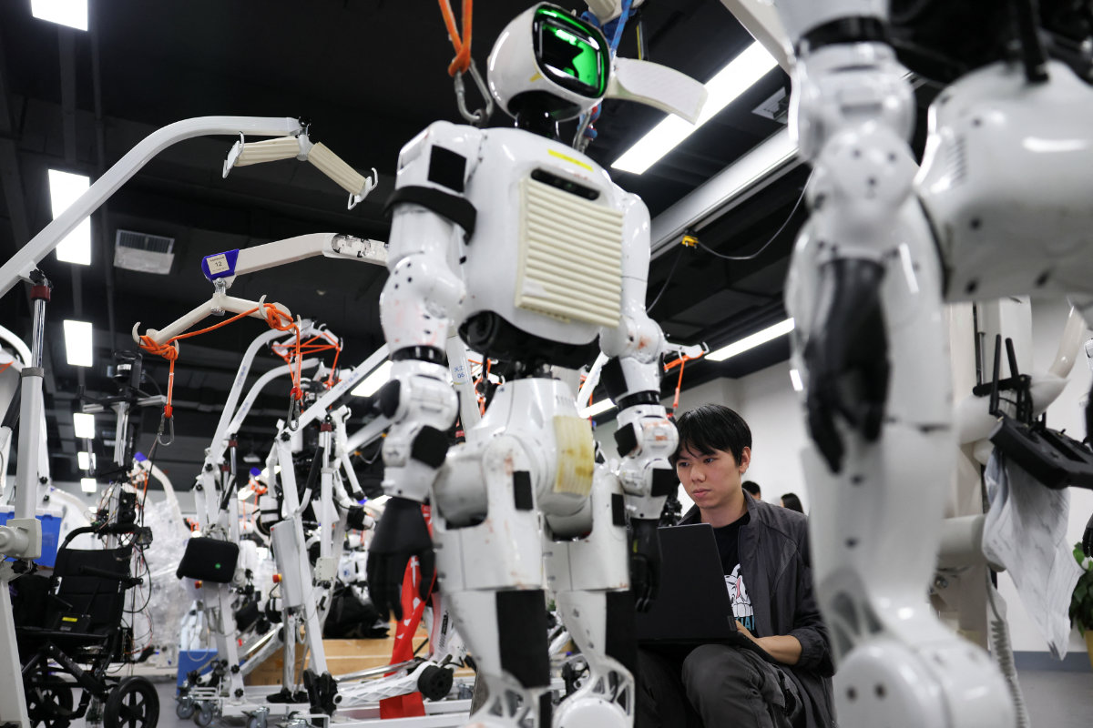 An engineer works near Tiangong Omni humanoid robots in the research and testing area of the Beijing Humanoid Robot Innovation Center, also known as X-Humanoid, in Beijing, China, September 4, 2026. (Reuters)