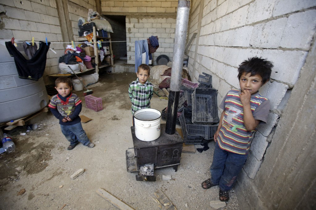 Syrian refugee children whose mother was killed while fleeing recent violence in Qussayr pose in the place they live with their father on June 14, 2013 in Arsal in the Lebanese Bekaa valley.