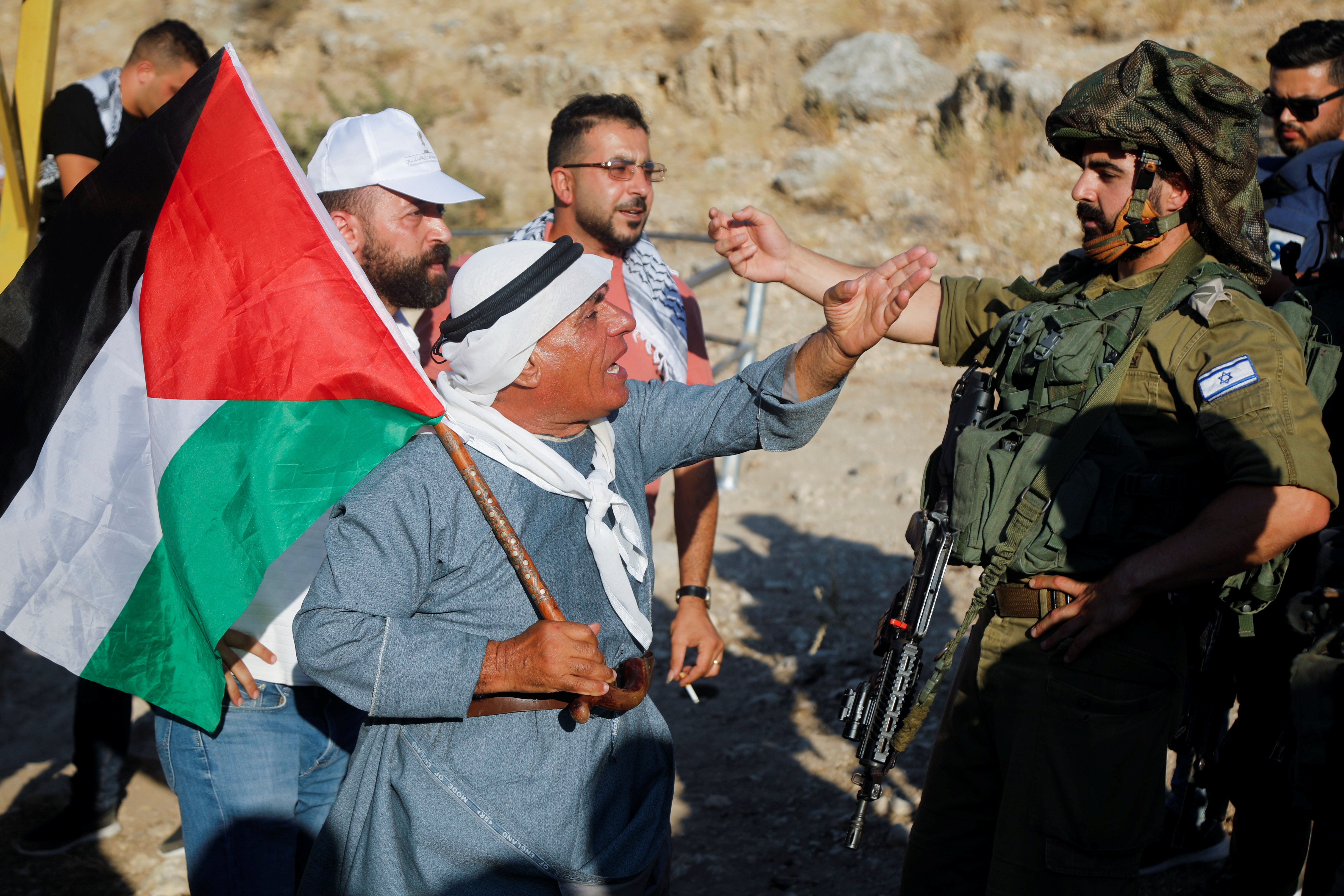 A Palestinian man clashes with an Israeli soldier during a protest in the West Bank, as tensions continue over land disputes and military presence in the region.