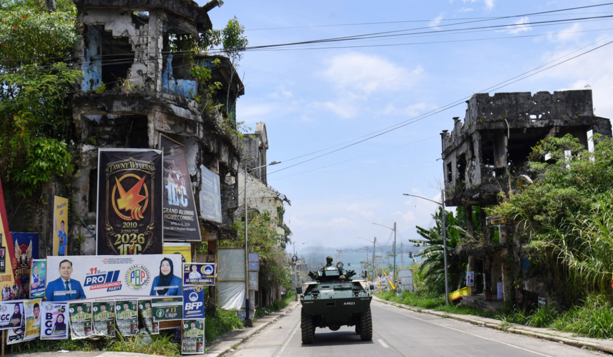 A military Armored Personnel Carrier patrols past destroyed houses and posters of candidates for the Bangsamoro Autonomous Region in Muslim Mindanao in Marawi, Lanao del sur province on the southern island of Mindanao. (AFP)