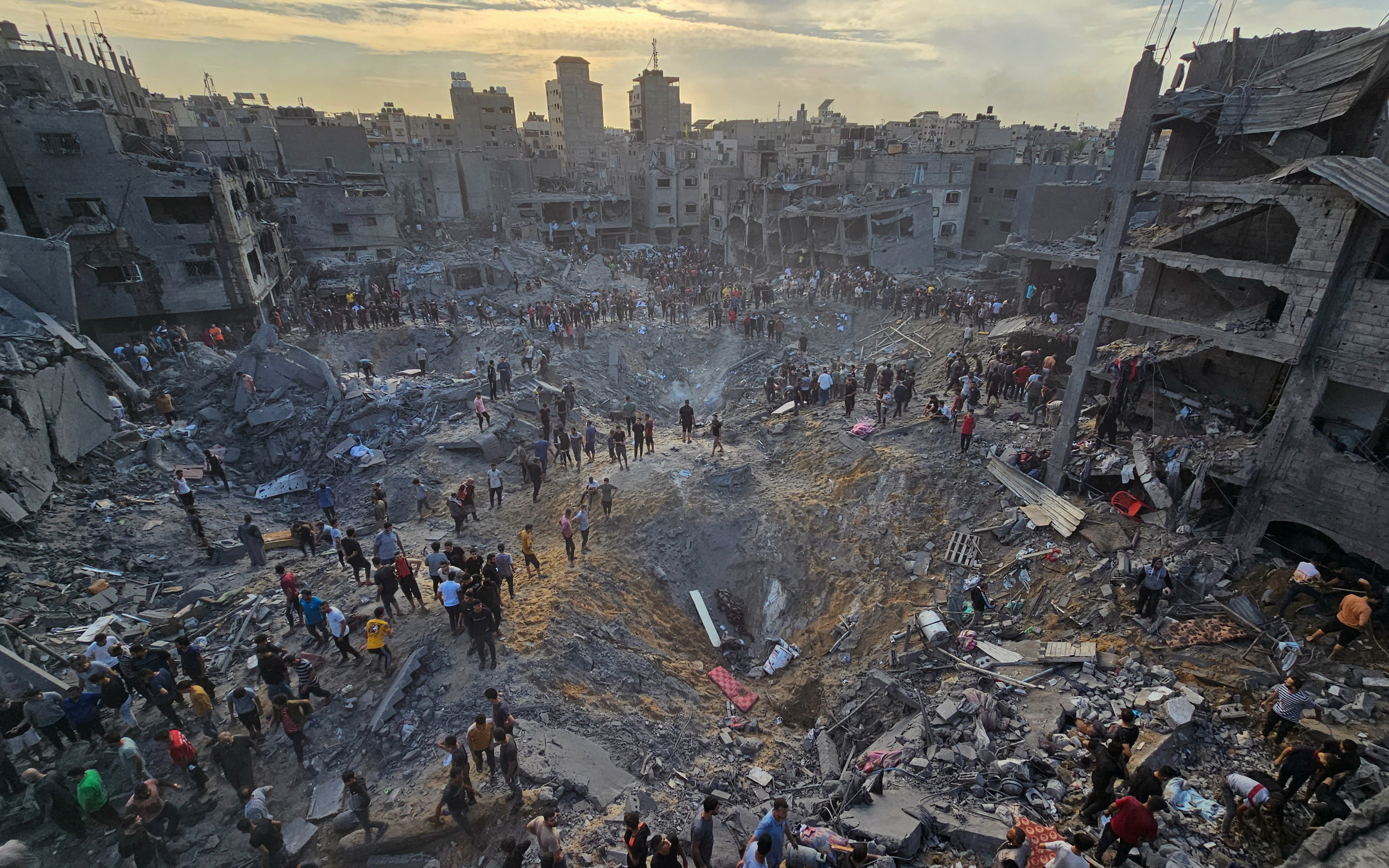 Palestinians search for casualties amid deep craters filled with broken concrete and twisted metal, after Israeli air strikes on the Jabalia refugee camp in the northern Gaza Strip, October 31, 2023.   REUTERS/File