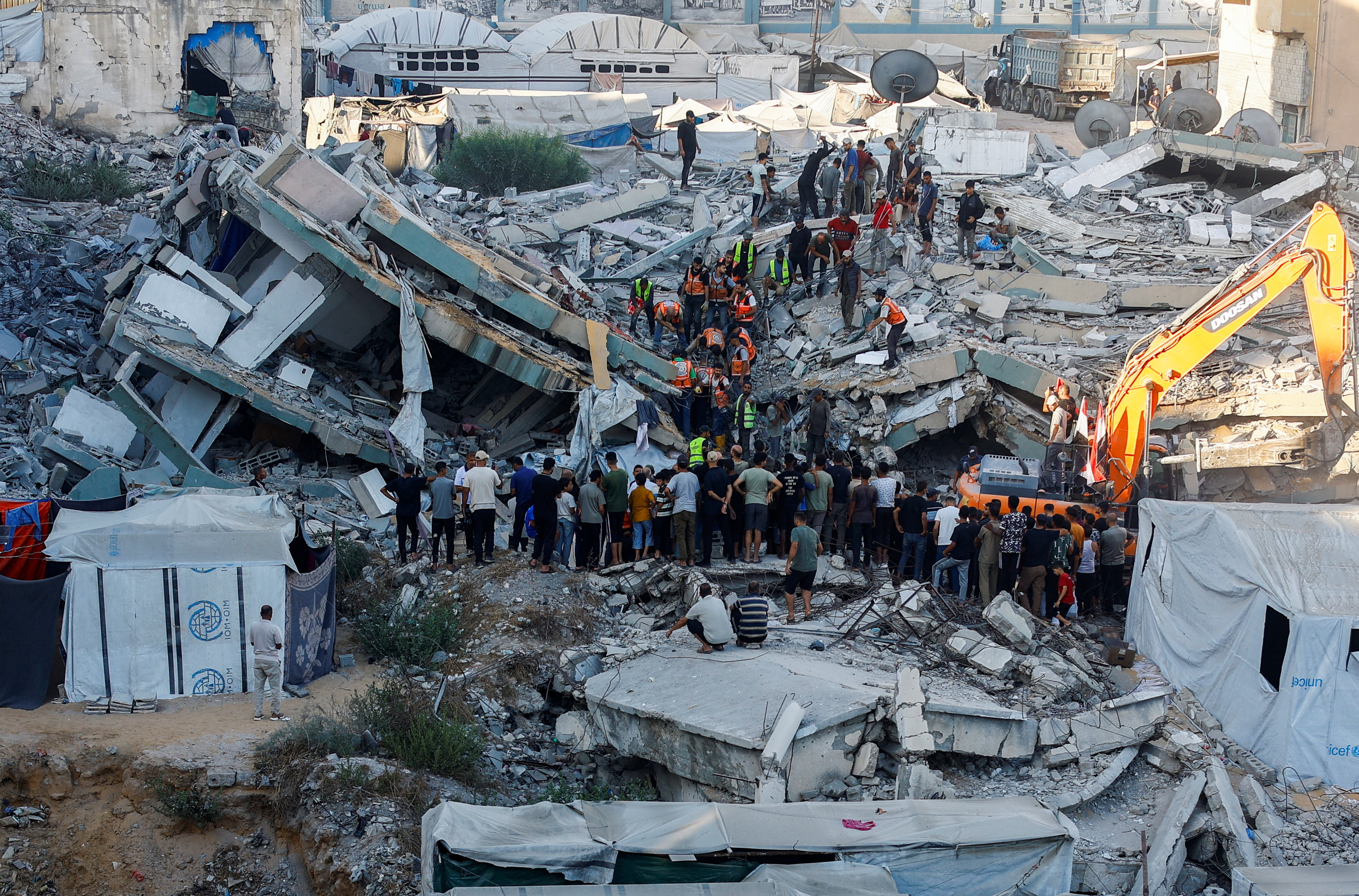 People gather as workers attempt to rescue those rapped beneath the rubble of a residential building in Gaza City. (Reuters)