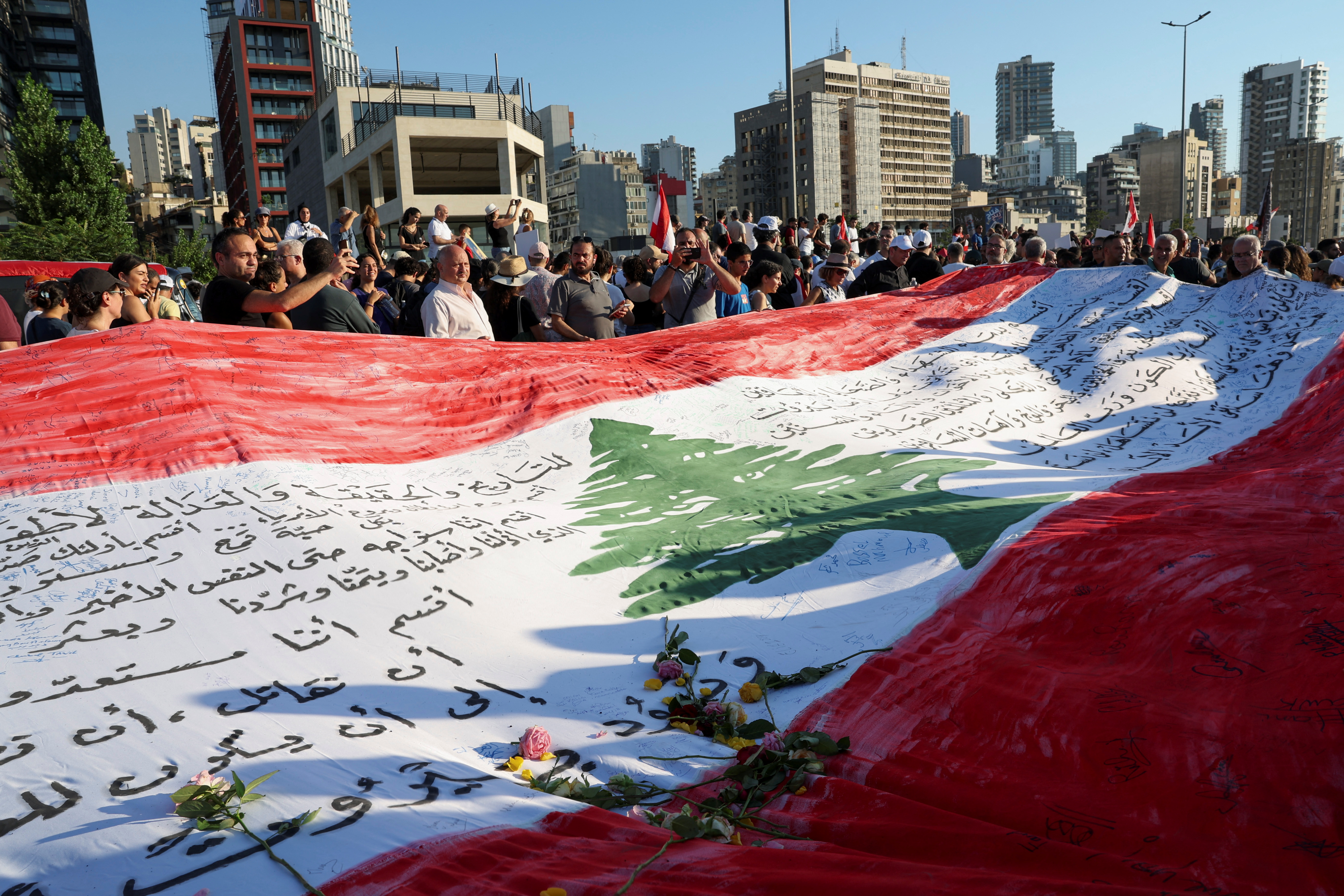 People hold a large Lebanese flag with flowers on it as they gather during a march, as Lebanon marks the three-year anniversary of the explosion in Beirut, Lebanon August 4, 2023. (REUTERS/File photo)