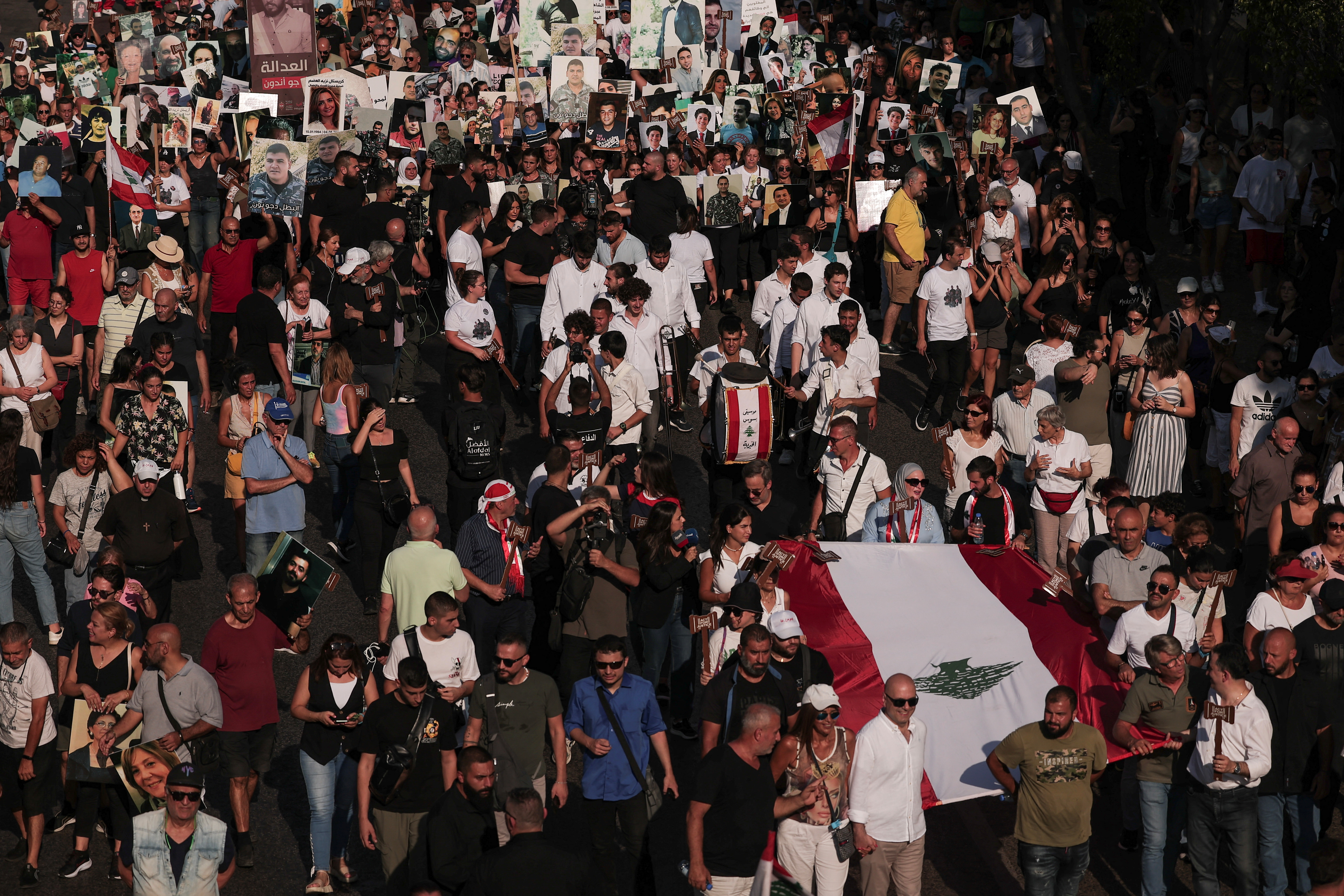 People hold a Lebanese flag during a march, as Lebanon marks the fourth anniversary of the explosion in the port of Beirut, Lebanon August 4, 2024. (REUTERS/File photo)