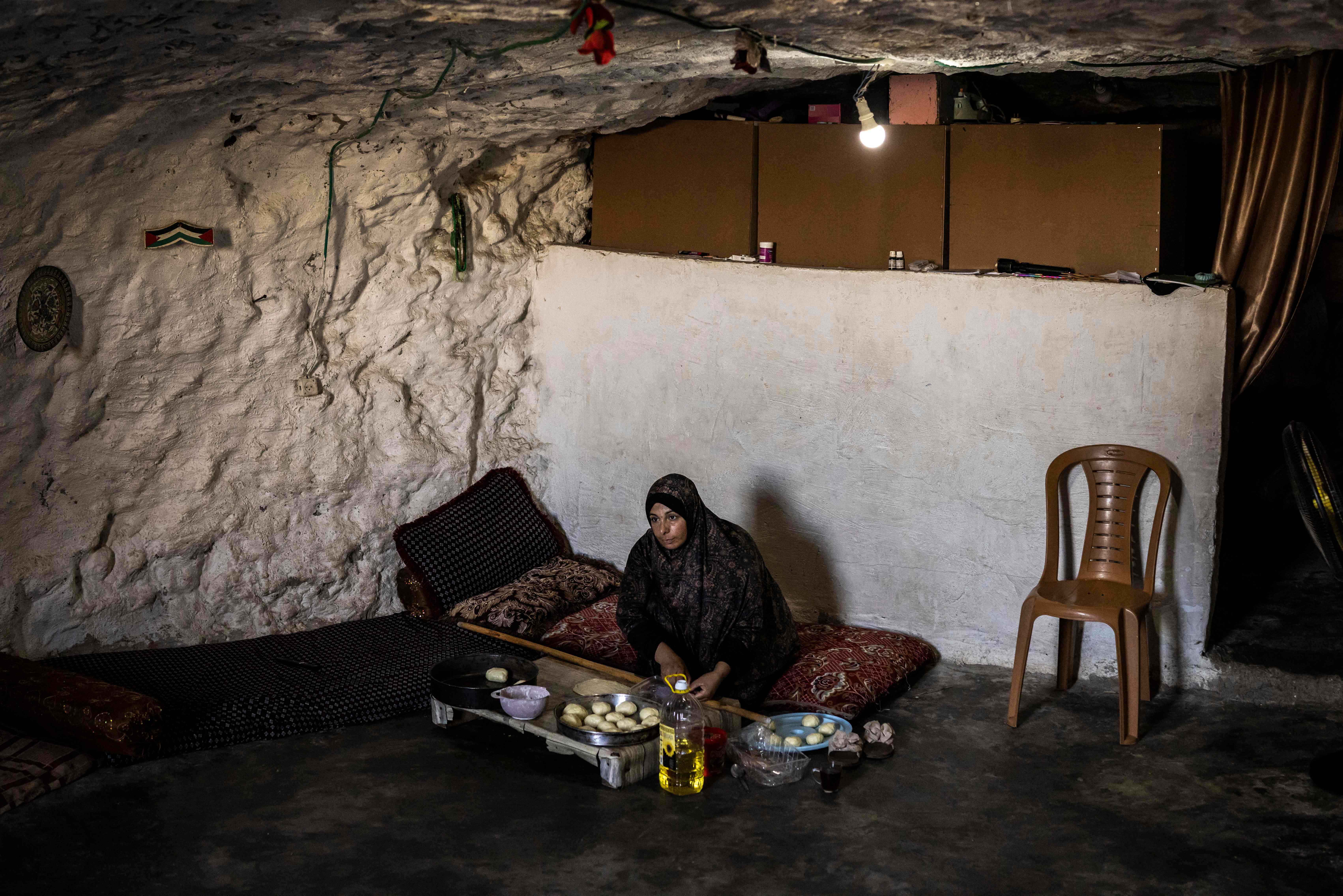 Fatma Amr bakes cakes at the cave that her family has turned into their home in the village of Al-Tuwani, in the Israeli-occupied West Bank. (AFP)