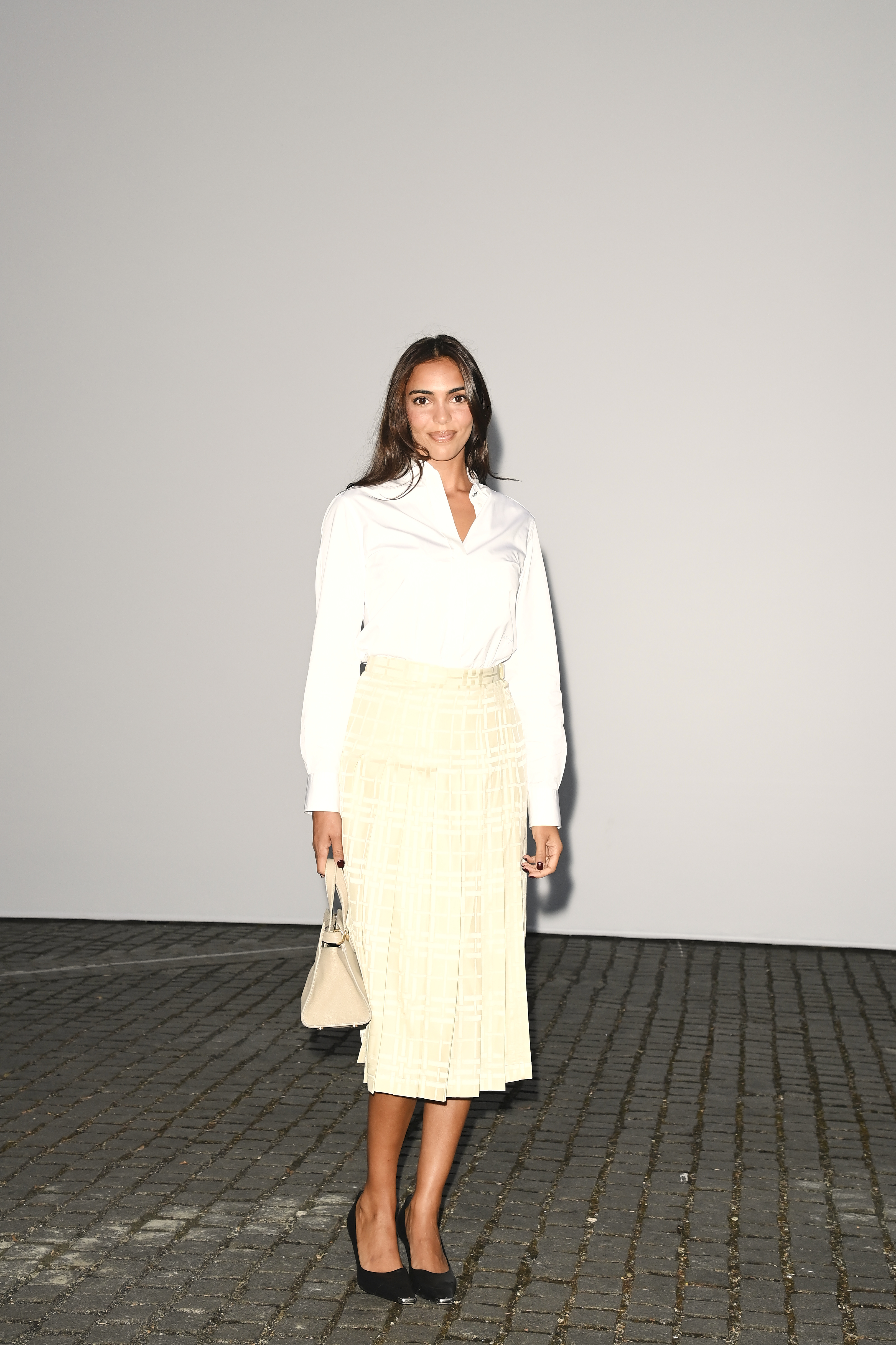 Shehab wore a crisp white shirt tucked into a pleated cream midi skirt in a sheer windowpane check. (Getty Images)