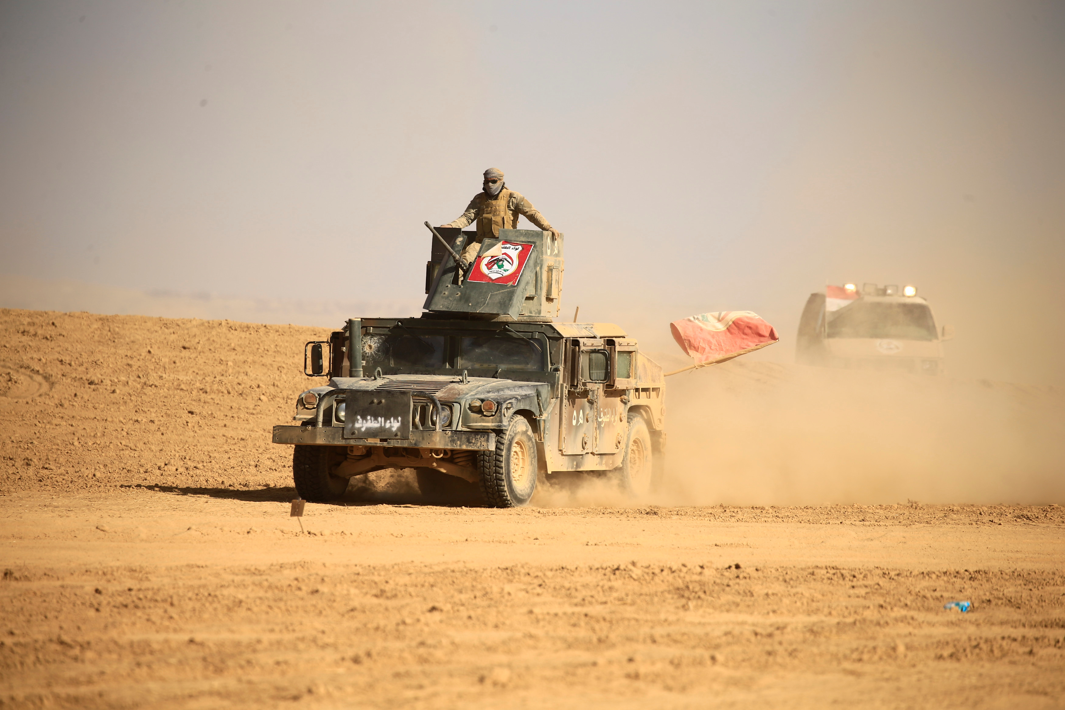 Members of the Shi’ite Badr Organisation fighters ride on military vehicles during a battle with Daesh militants at the airport of Tal Afar west of Mosul, Iraq November 18, 2016. (Reuters file)