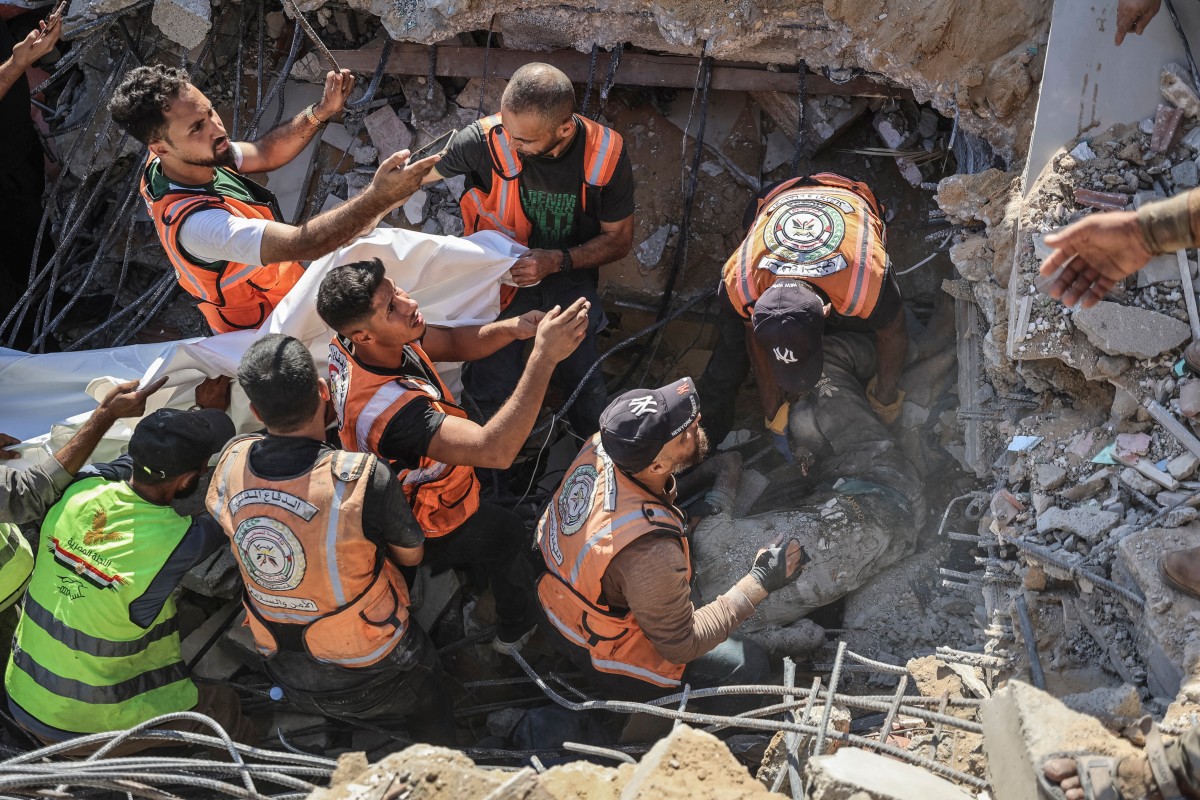 Volunteers and rescuers carry a body recovered from the rubble of a collapsed building in the Tal al-Hawa area of Gaza City on September 16, 2026. (File/AFP)