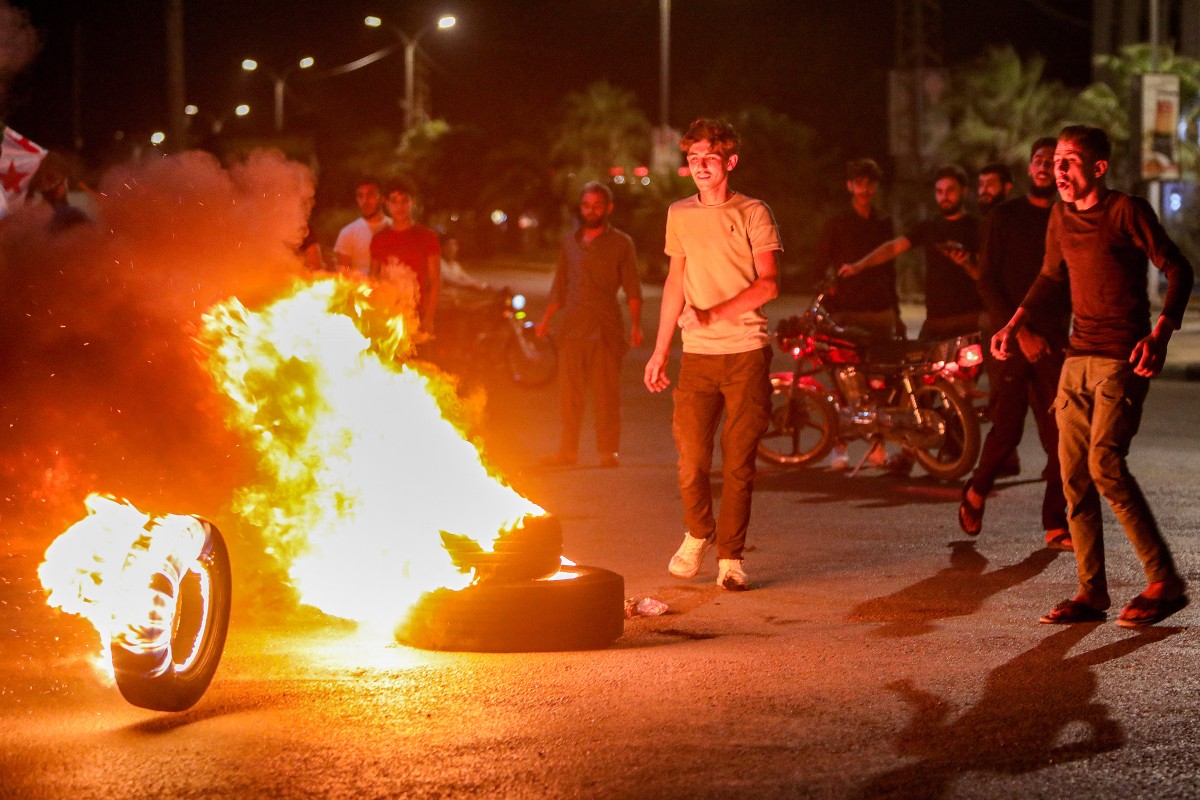 Demonstrators block a road with flaming tires while protesting hikes to fuel prices in Al-Bab, northeast of Aleppo in northern Syria, on September 14, 2026. (AFP)