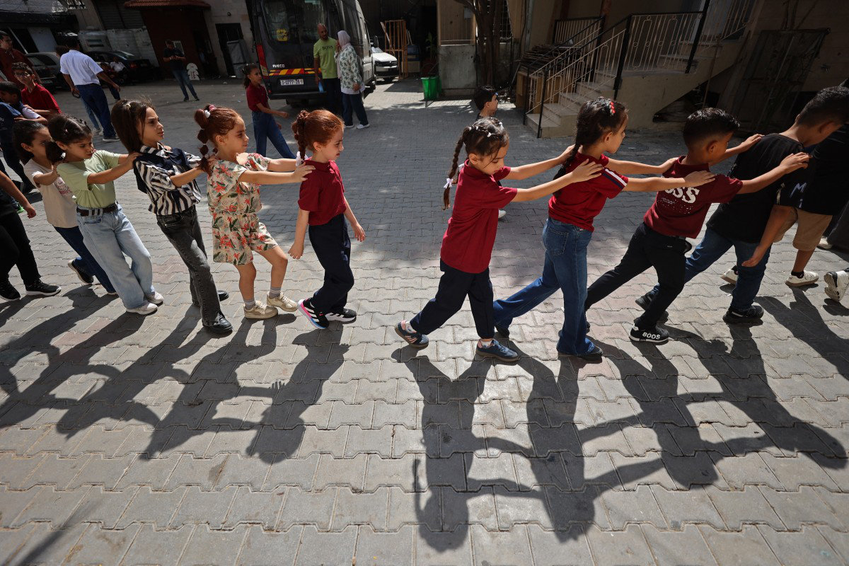 Palestinian children make their way to school as the academic year begins in Khan Yunis, in the southern Gaza Strip on September 19, 2026. (AFP)