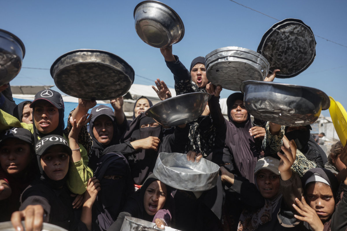 Displaced Palestinian women gather to receive hot meals distributed by a charity kitchen in Khan Yunis in the southern Gaza Strip on September 25, 2026. (AFP)
