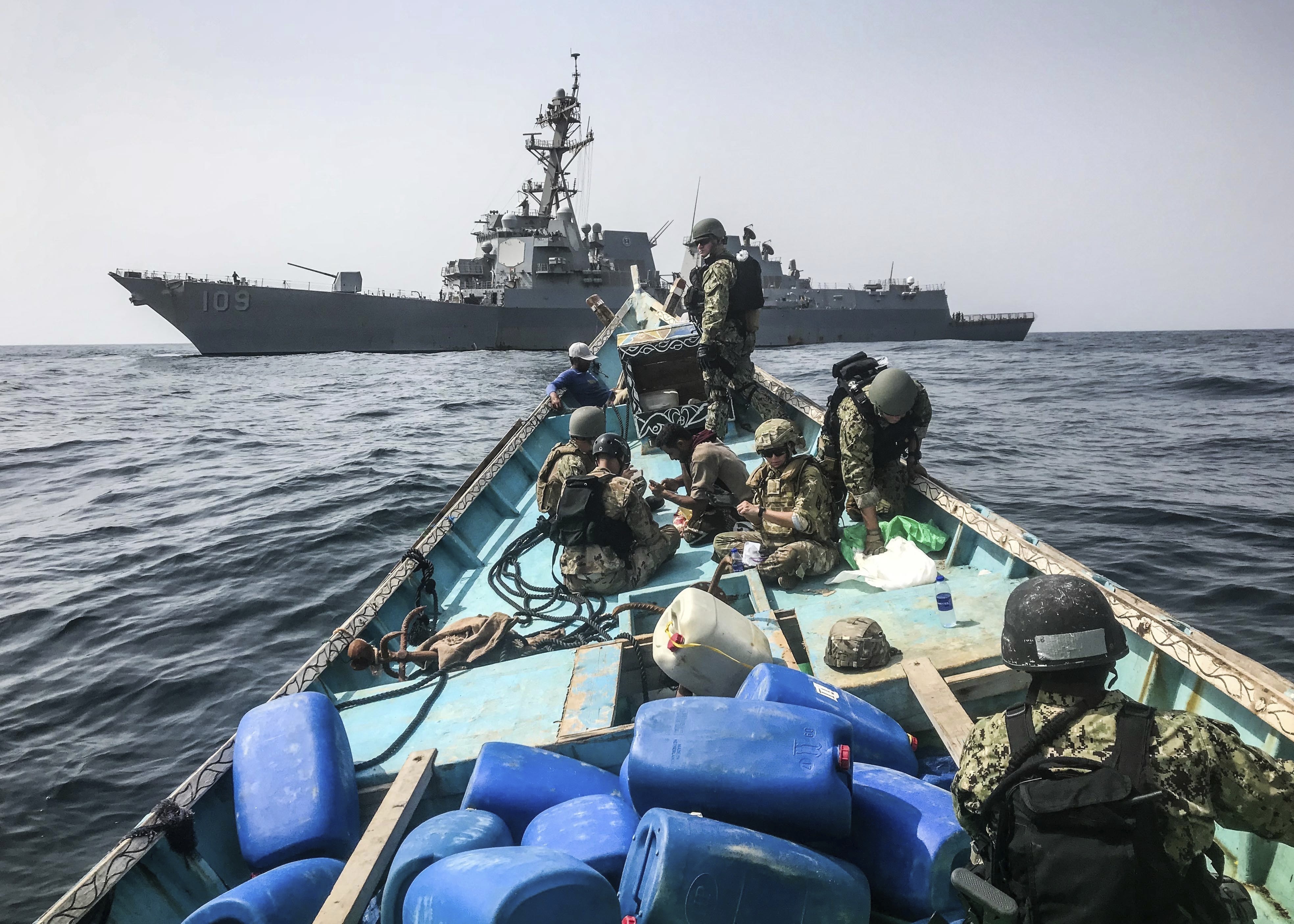 A team from the guided-missile destroyer USS Jason Dunham inspects a dhow while conducting maritime security operations. (AP Photo)