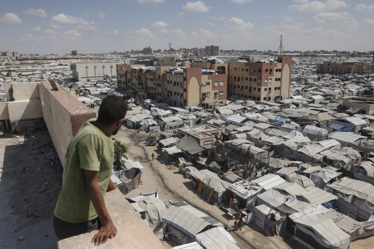 A man standing on top of a building looks at tents of displaced Palestinians in Al-Mawasi area of Khan Yunis in the southern Gaza Strip on Sept. 25, 2026. (AFP)