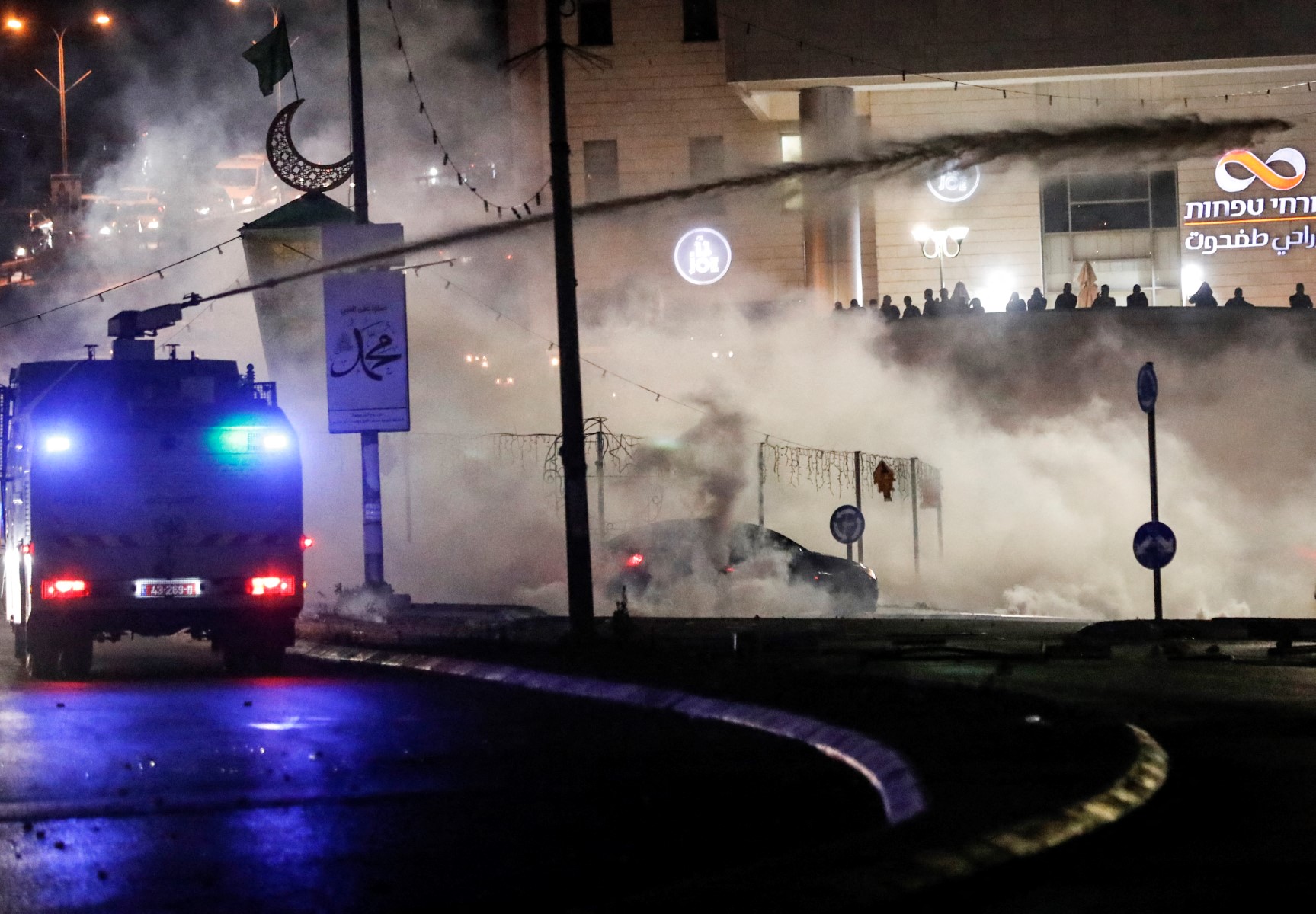 Israeli security forces spray Palestinian protesters with skunk water during confrontations with them in the mostly Arab city of Umm Al-Fahm in northern Israel, on May 19, 2021. (AFP)