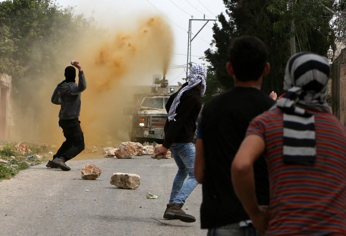 Israeli security forces spray foul-smelling water known as "skunk" towards Palestinian stone throwers during clashes following a demonstration against the expropriation of Palestinian land by Israel in the village of Kfar Qaddum, near Nablus, in the Israeli-occupied West Bank, on March 25, 2016. (AFP)