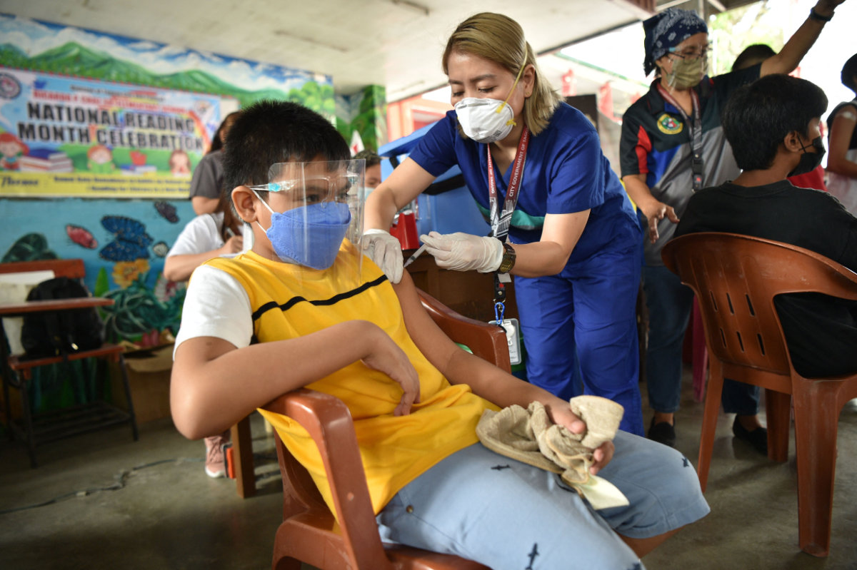 Medical workers prepares BioNtech-Pfizer Covid-19 coronavirus vaccines during an innoculation drive at a school gym in Taguig City, suburban Manila on December 6, 2021. (AFP/File)