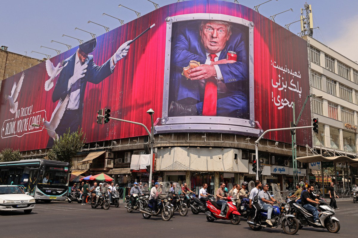 Motorists ride past a billboard depicting US President Donald Trump inside a catering container, installed on a building along a street in downtown of Tehran on August 31, 2026. (AFP)