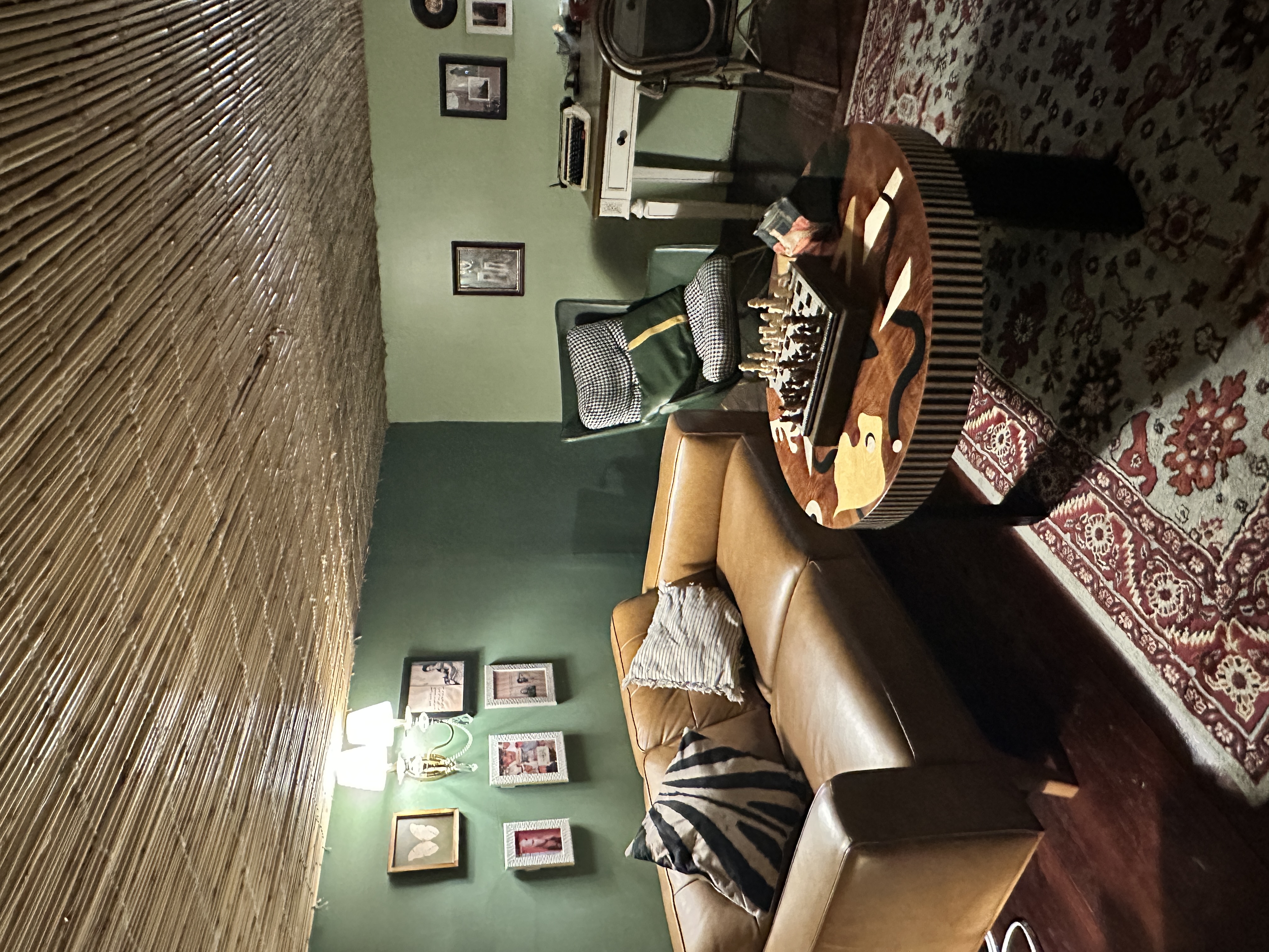 Muted green walls, a reed-covered ceiling and eclectic furniture create a relaxed, lived-in atmosphere. (AN photo/Nada Hameed)