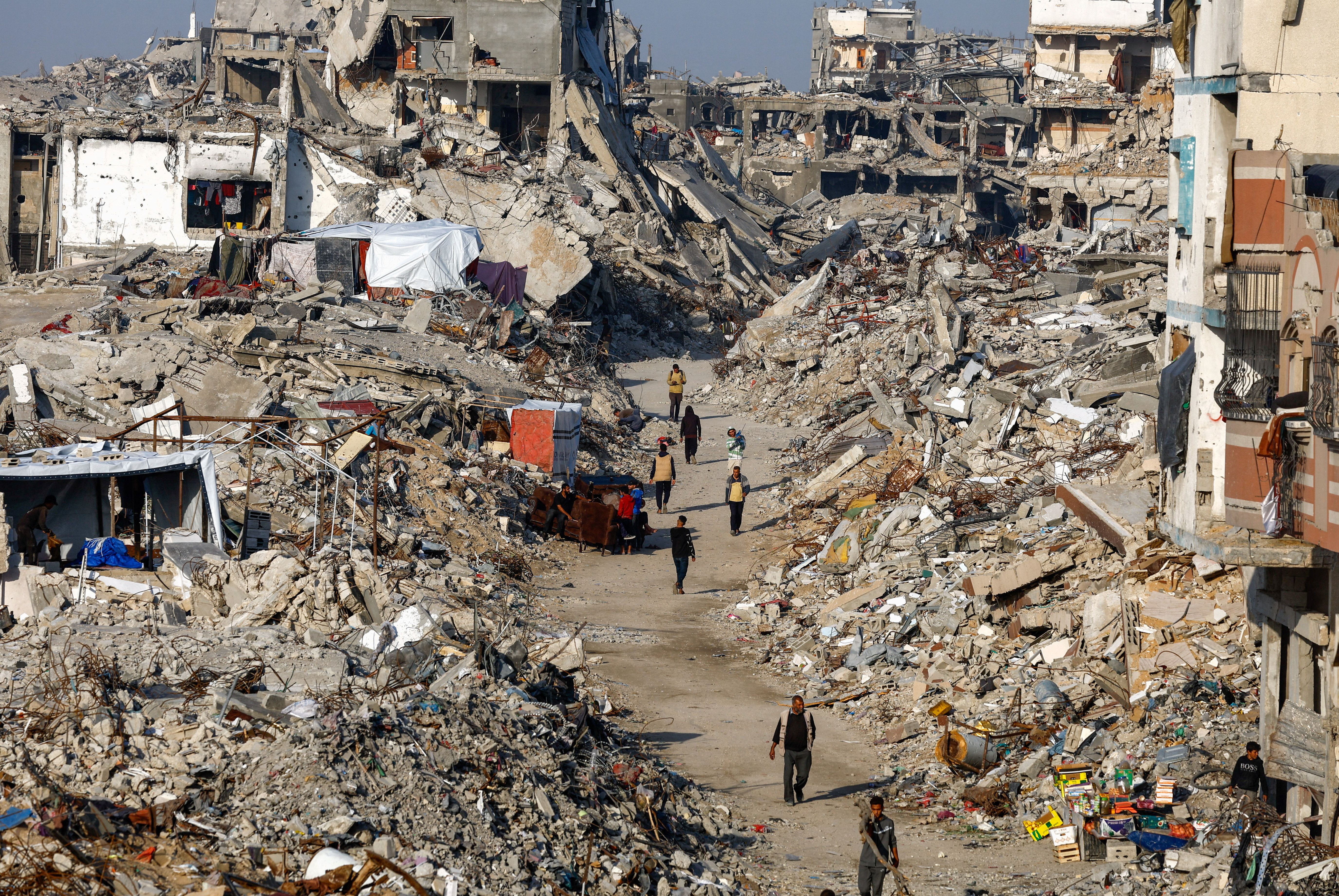 Palestinians walk among piles of rubble and damaged buildings in the northern Gaza Strip on Nov 19, 2025. (Reuters file)