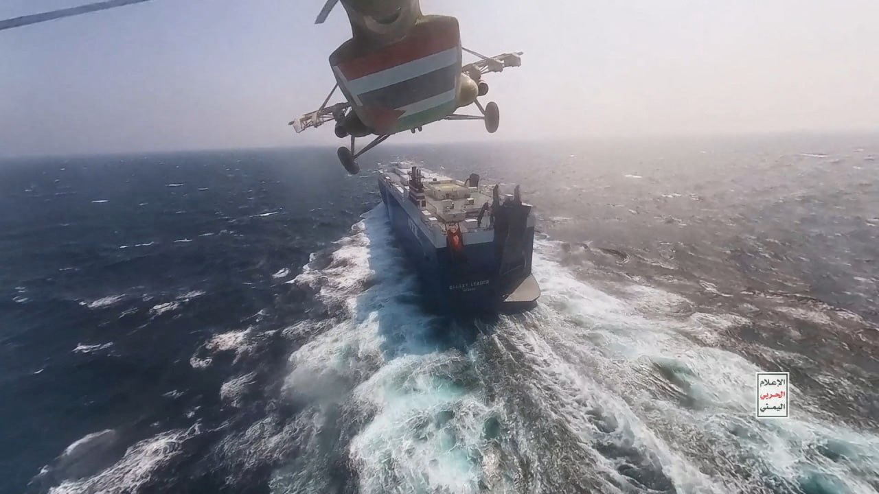 Houthi military helicopter flies over the Galaxy Leader cargo ship in the Red Sea. Closing the waterway completely would damage the economic interests of countries with important political relationships with the group. (Reuters)