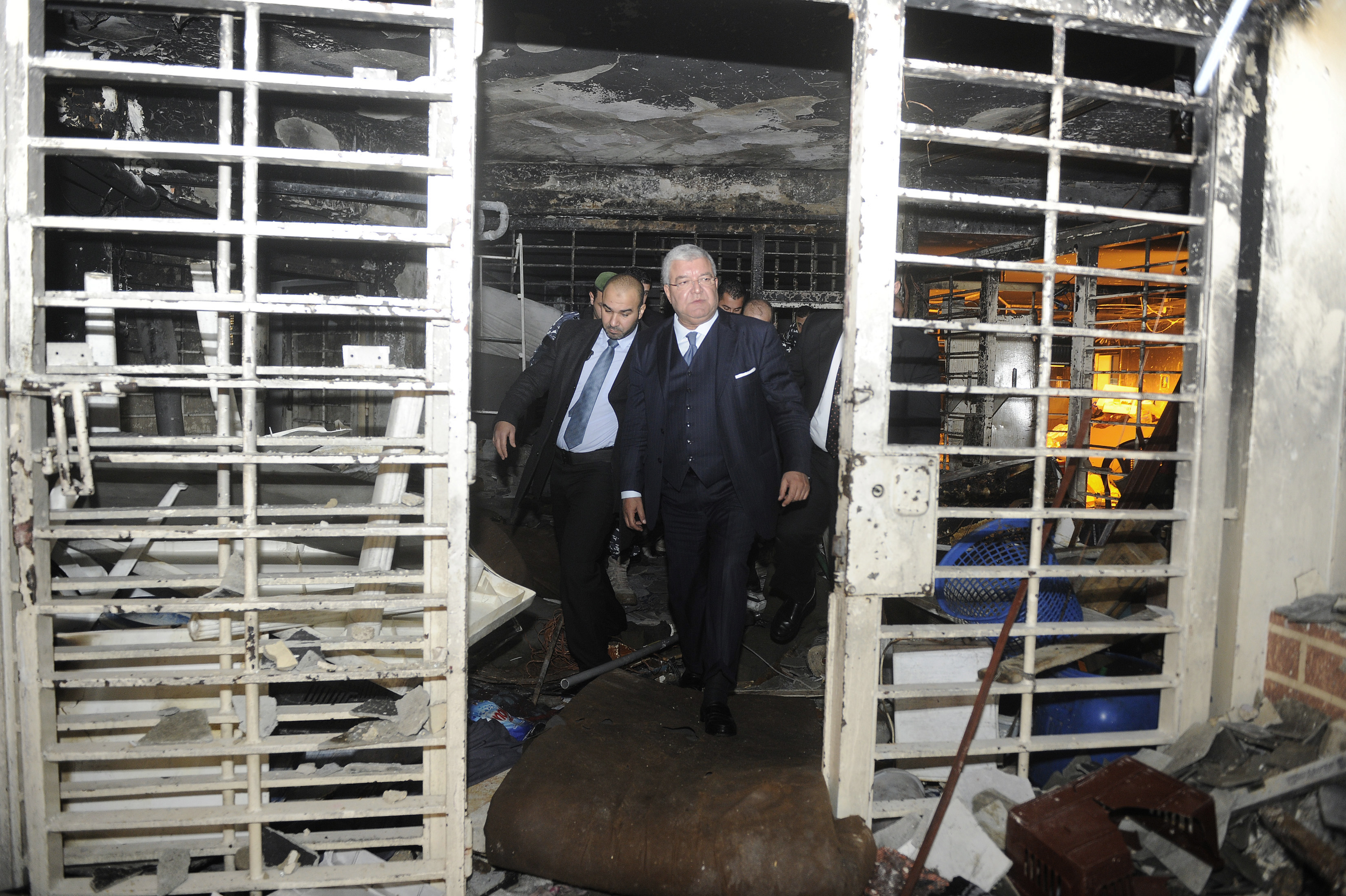 Former Lebanon's Interior Minister Nohad Machnouk (C) walks through the damaged interior of a section of Roumieh prison. Prisons in Lebanon have long faced problems with overcrowding and delays in court proceedings. (Reuters)
