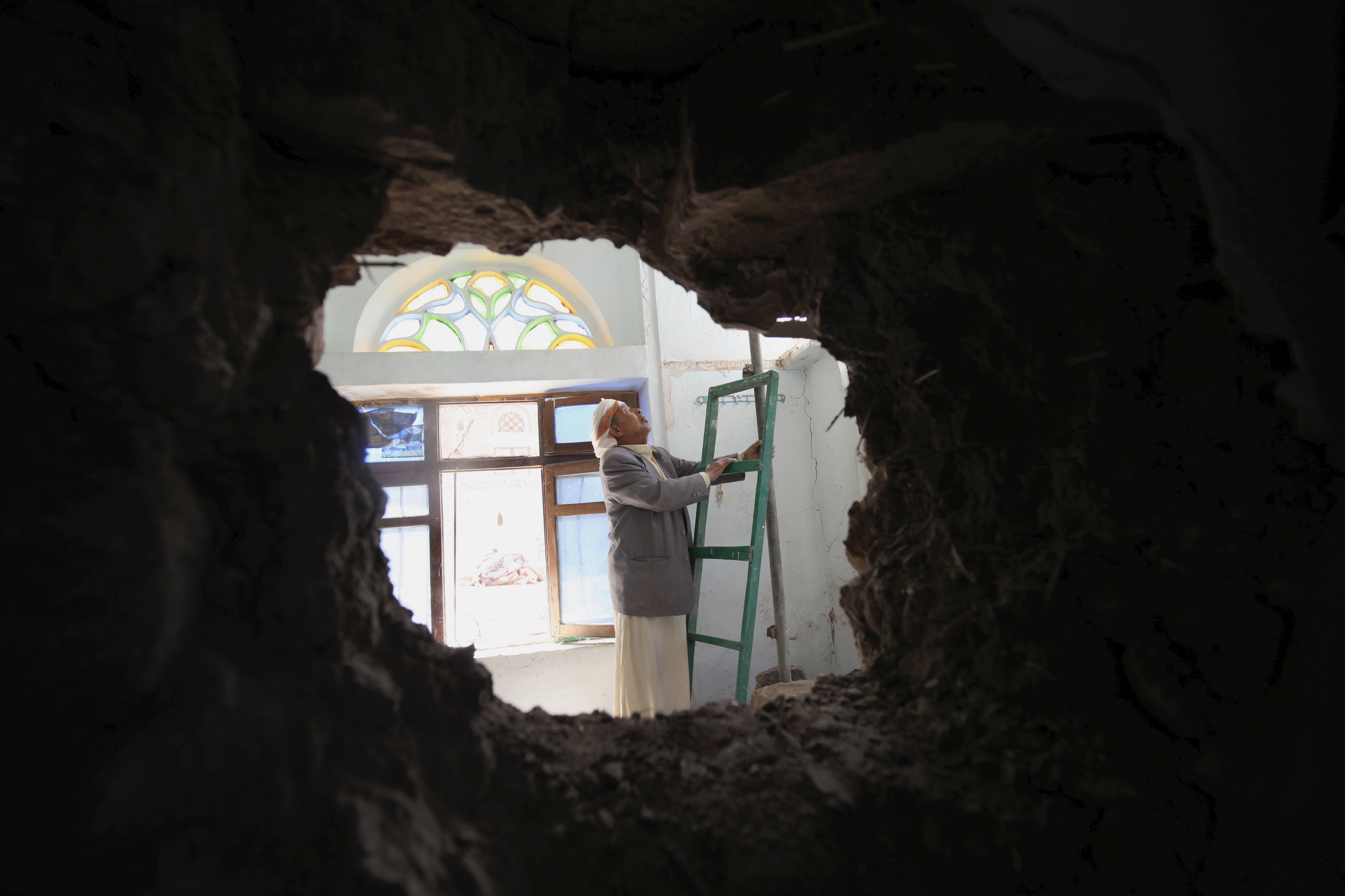 A man looks at his home, which was damaged by a shell that landed from an army weapons depot after the depot was hit in an air strike, in old Sanaa city, May 19, 2015. (Reuters file)