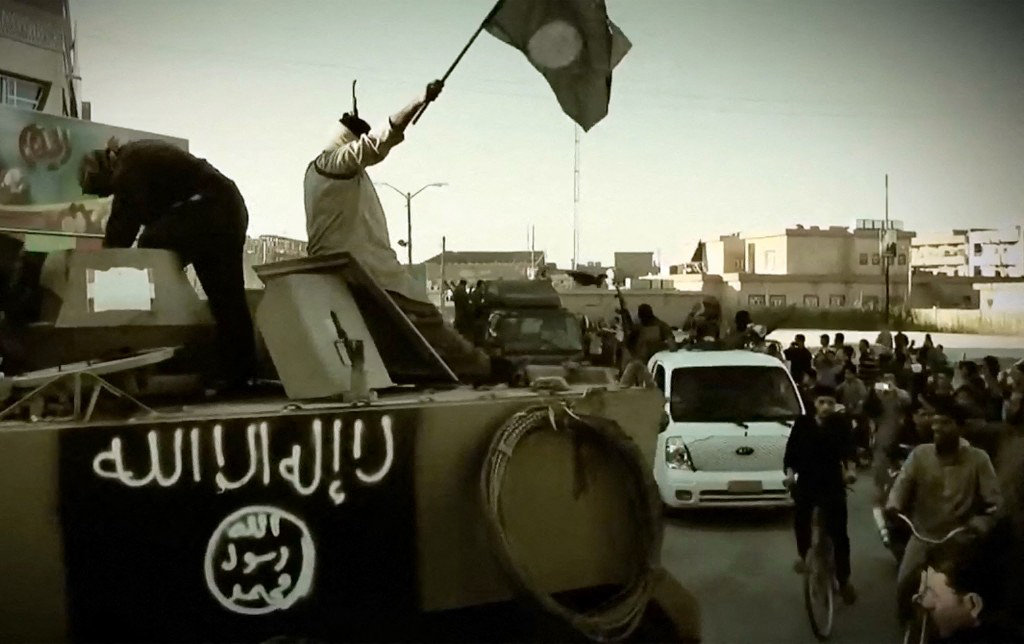 An image grab taken from a propaganda video released on March 17, 2014 by the Daesh group, also known as ISIL or ISIS, shows fighters displaying the trademark Jihadists flag in Anbar province, Iraq. (AFP File)