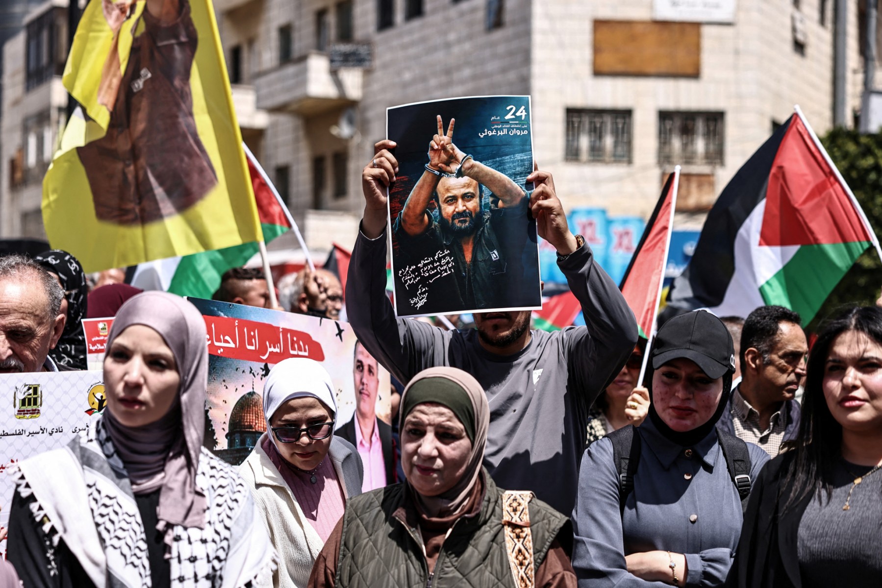 Palestinian demonstrators hold pictures of prisoners held in Israeli jails, including jailed Palestinian leader Marwan Barghouti, during a rally in Ramallah in the occupied West Bank on April 16, 2026 to mark Prisoners' Day. (AFP)