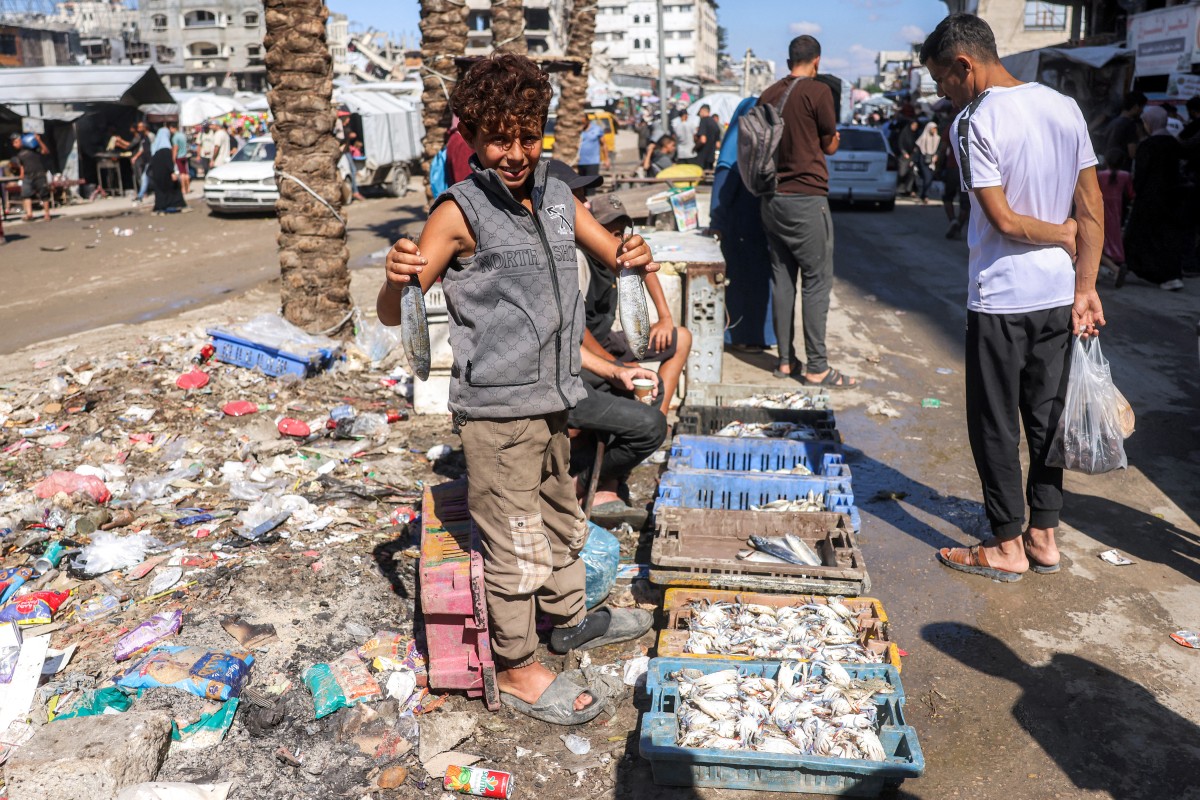 A young vendor sells fish at a market in the Jabalia camp for Palestinian refugees in the northern Gaza Strip on October 19, 2026. (AFP)