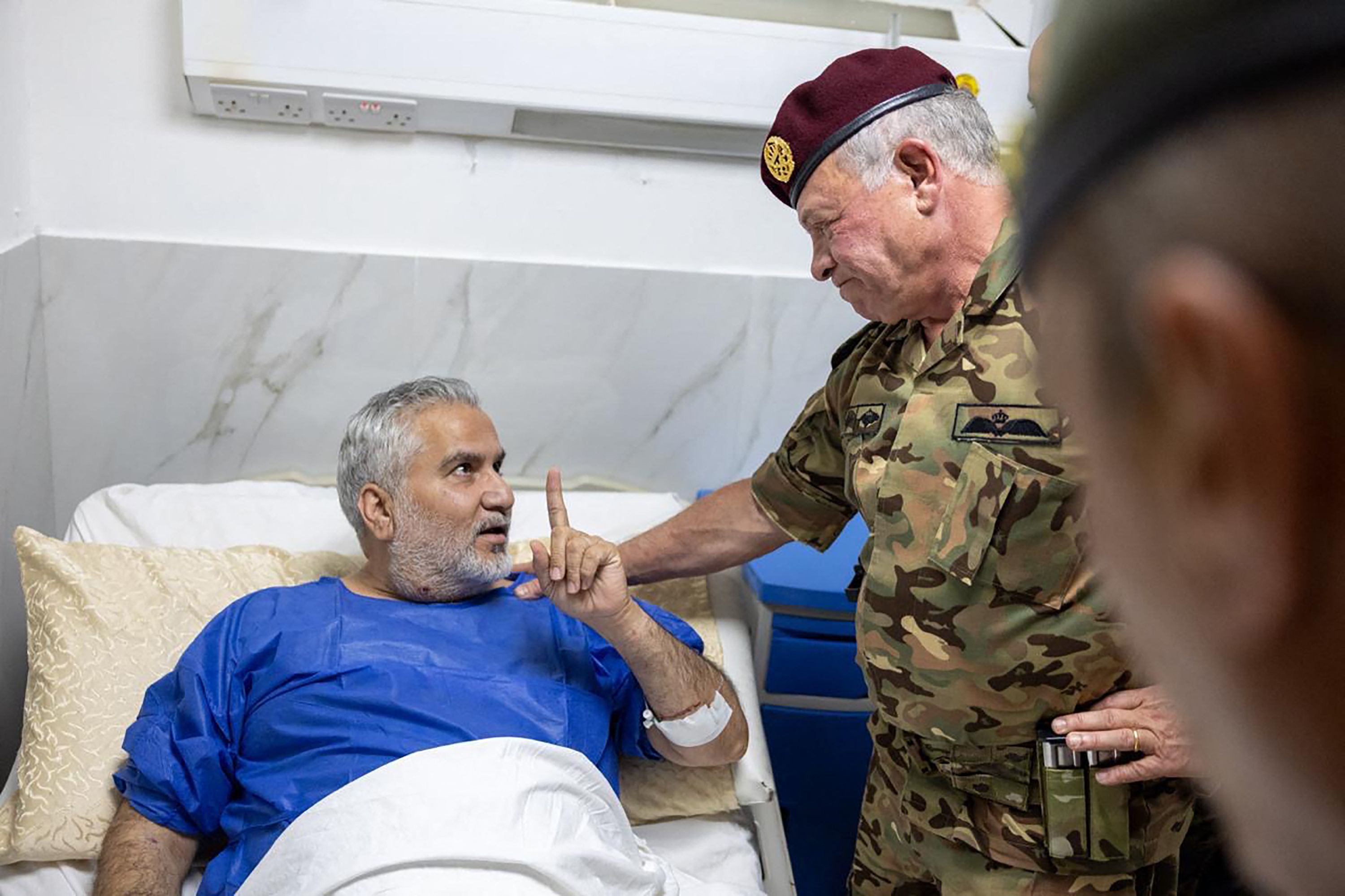 Jordan's King Abdullah II visits people wounded in an attack on a church in Karak on Friday.