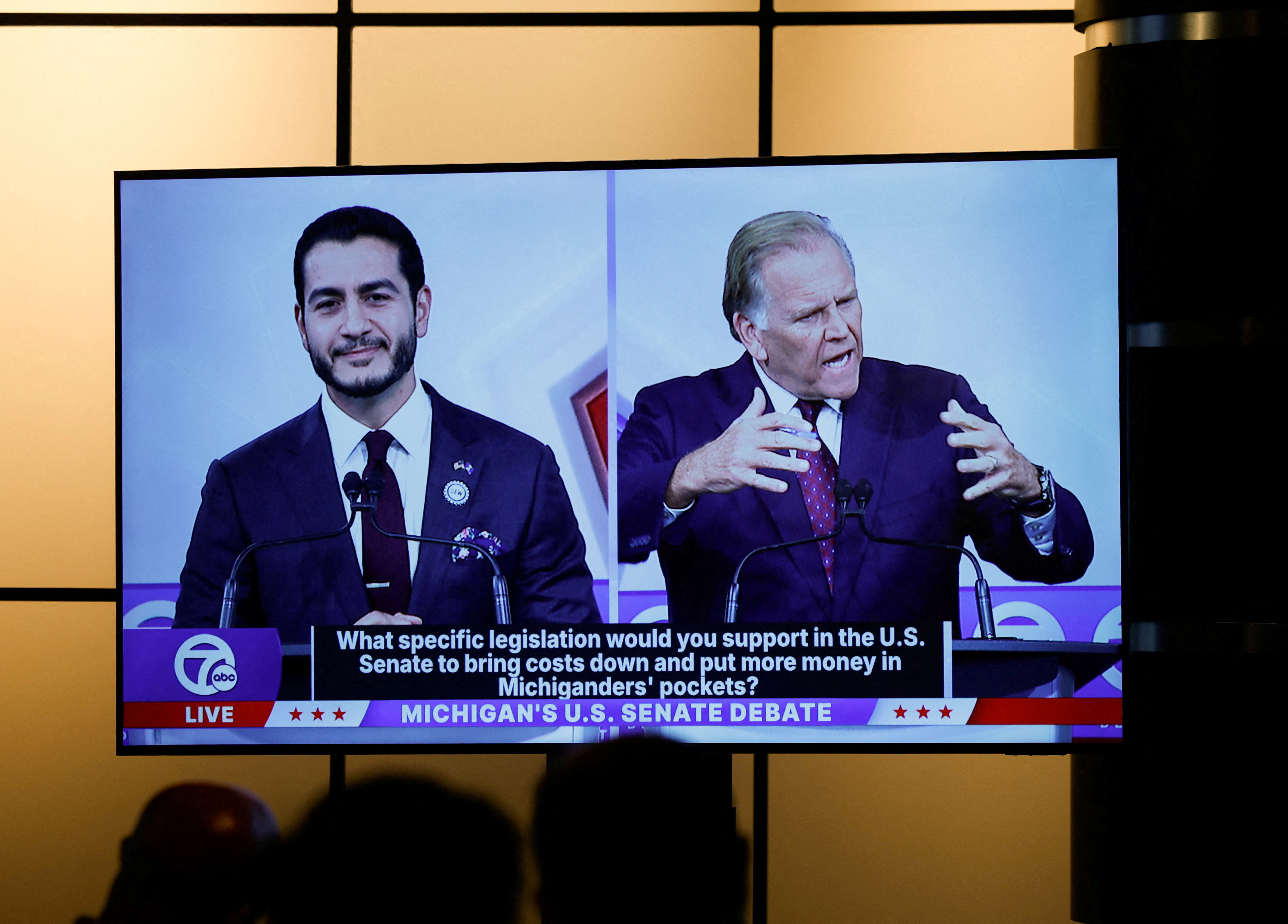 Democratic nominee for US Senate Abdul El-Sayed and Republican nominee for US Senate Mike Rogers are seen on a screen in the media room during their US Senate debate in Southfield, Michigan, October 21, 2026. (REUTERS)