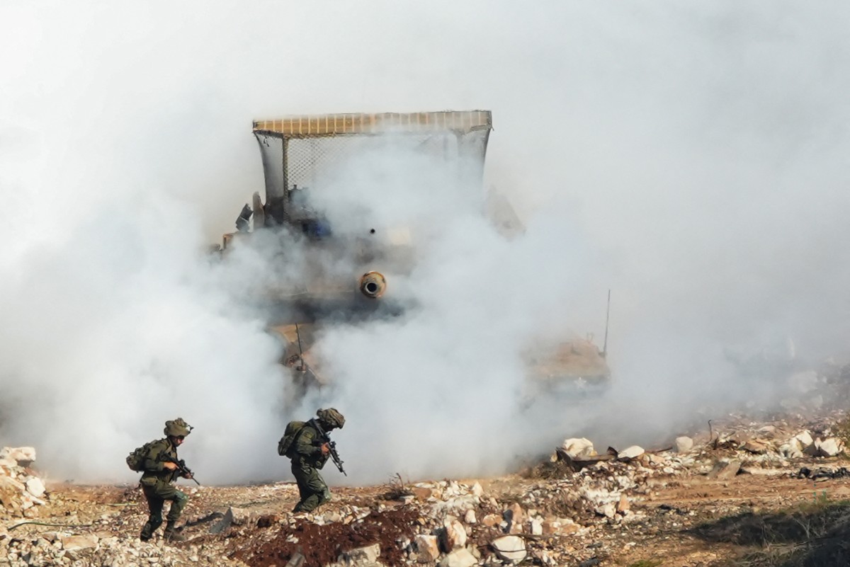 This photograph taken from the southern Lebanese village of Zawtar Al-Gharbiya shows Israeli soldiers, supported by a tank, conducting an operation in the nearby village of Zawtar Al-Sharkiya on October 25, 2026. (AFP)