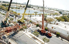 2 hurt as crane crashes down on cars