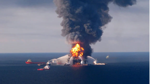 Burning oil rig sinks, setting stage for big spill