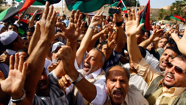 Libyan fighters stream home to fanfare, bristling with guns