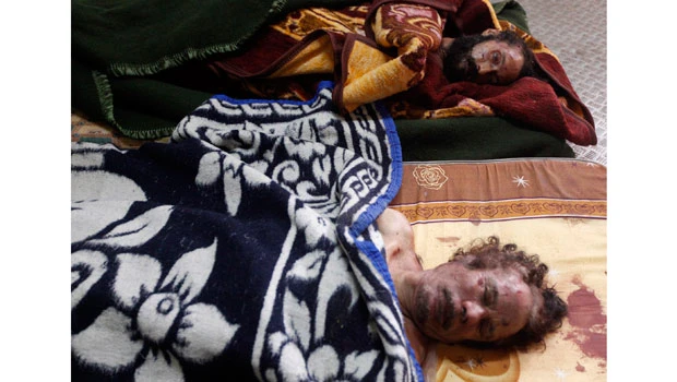 Qaddafi still on show, rotting as wrangling goes on