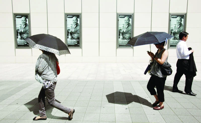 Japanese men drop inhibition,use parasols to beat the heat