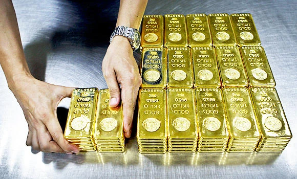 Gold falls to one-month low as Fed comments lift dollar