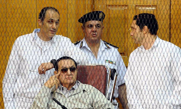 Egypt’s Mubarak waves, grins as his trial resumes