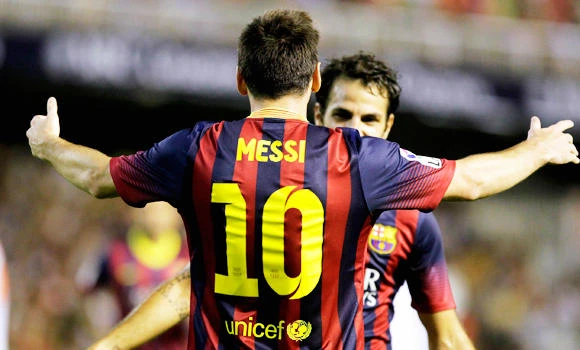 Messi hat-trick keeps Barca on top