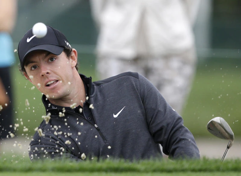 McIlroy clings to lead; Woods struggles to make cut
