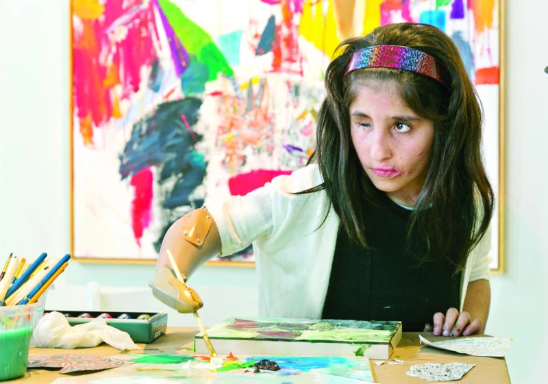Afghan girl with prosthetic arm carves out a new life
