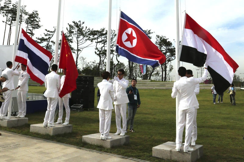 Smiles and scrums as North Korea flag goes up