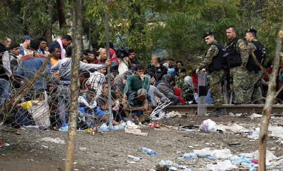 Chaos as migrants rush past police into Macedonia