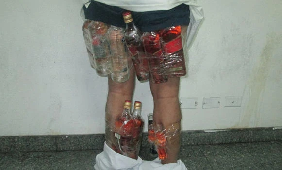 Smuggler caught with bottles of liquor taped to his legs