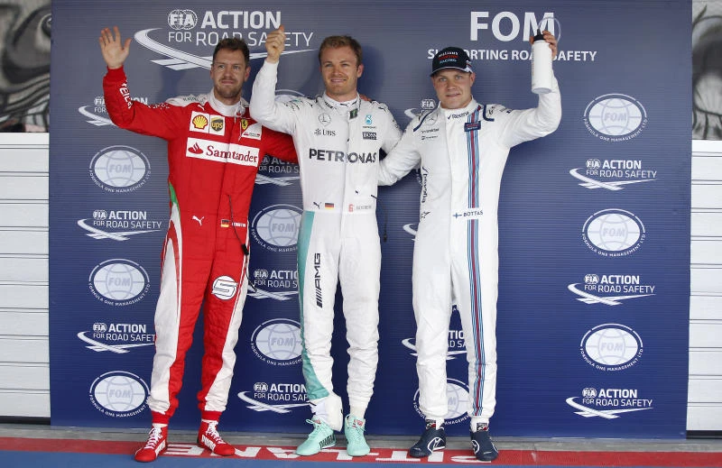 TOP THREE: Nico Rosberg, center, celebrates after setting the pole position with the second placed Sebastian Vettel, left, and third placed Valtteri Bottas, during the qualifying session for Sunday's Formula One Russian Grand Prix at the Sochi Autodrom racetrack, in Sochi, Russia, Saturday. (AP)