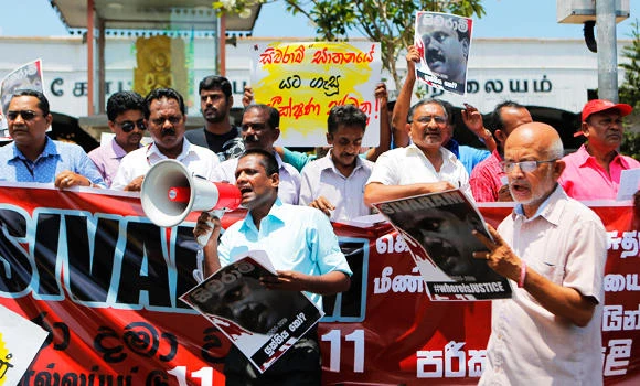 Sri Lankan journalists shout slogans holding a portrait of killed journalist Dharmeratnam Sivaram during a protest in Colombo, Sri Lanka, on Friday. (AP)